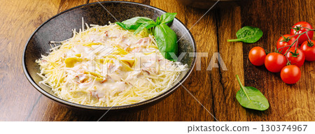 Creamy pasta dish garnished with fresh herbs and cherry tomatoes Creamy pasta dish garnished with fresh herbs and cherry tomatoes 130374967