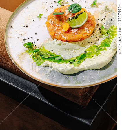 Gourmet dish served on a stylish plate in a modern restaurant setting 130374994