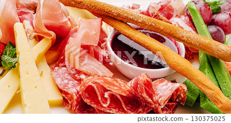 Delicious assortment of charcuterie with cheeses and accompaniments on display 130375025