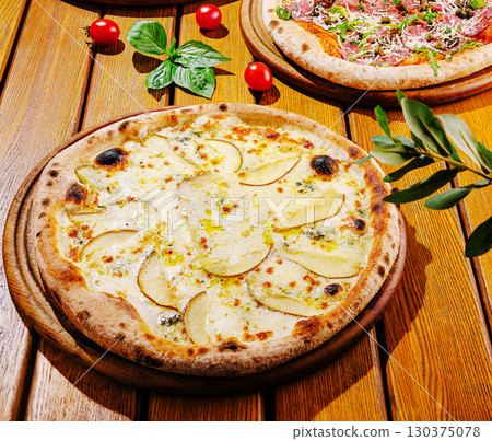 Delicious pizza topped with fresh ingredients on a wooden table Delicious pizza topped with fresh ingredients on a wooden table 130375078
