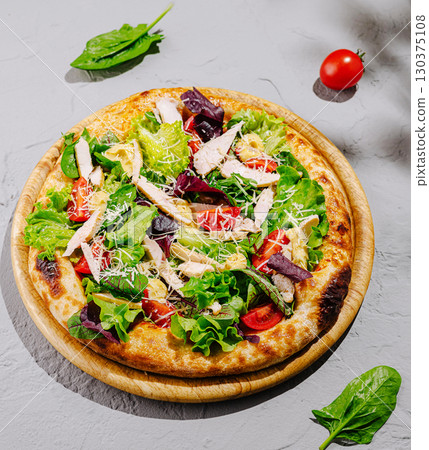 Delicious salad pizza topped with fresh vegetables and grilled chicken Delicious salad pizza topped with fresh vegetables and grilled chicken 130375108