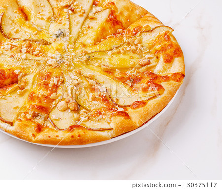Delicious pear and walnut pizza served on a white plate 130375117