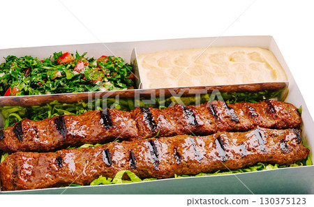 Delicious skewers served with fresh salad and creamy dip at a local eatery Delicious skewers served with fresh salad and creamy dip at a local eatery 130375123