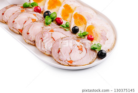 Culinary platter featuring savory rolled meats with colorful garnishes 130375145