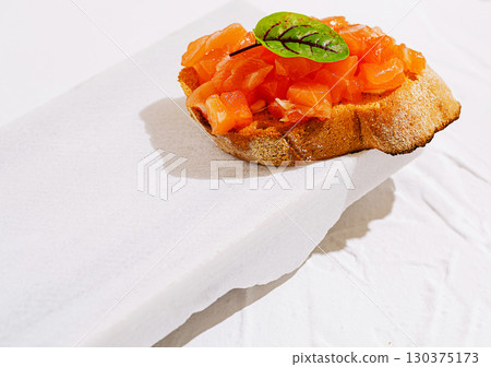 Delicious tomato bruschetta served on a rustic wooden board in daytime 130375173