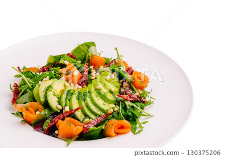 Fresh salad with avocado, smoked salmon, and pine nuts on a white plate 130375206