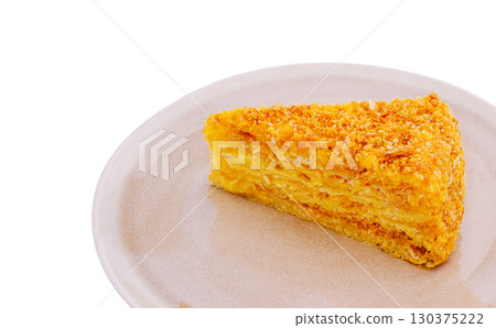 Moist, golden slice of delicious cake on a simple plate with white background Moist, golden slice of delicious cake on a simple plate with white background 130375222