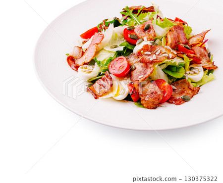 Fresh salad with crispy bacon and mixed vegetables on a white plate 130375322