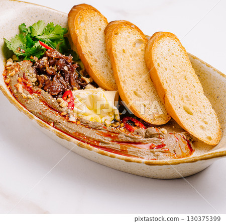 Appetizer with liver pate, caramelized onions and toasted baguette slices 130375399
