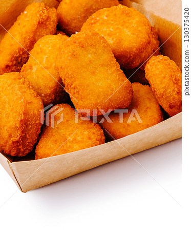 Crispy golden chicken nuggets served in a cardboard box 130375420