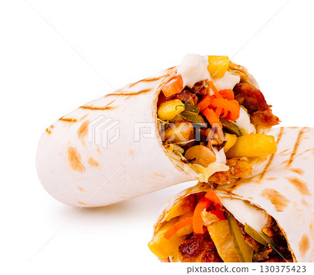 Grilled wrap filled with fresh vegetables and savory meat at a food truck 130375423