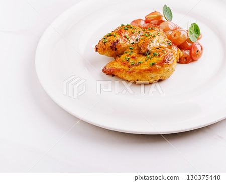 Delicious baked chicken dish served with cherry tomatoes and herbs Delicious baked chicken dish served with cherry tomatoes and herbs 130375440