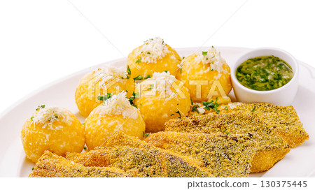 Crispy fish with golden balls served with green sauce and herbs Crispy fish with golden balls served with green sauce and herbs 130375445