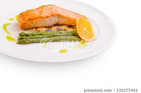 Grilled salmon fillet with asparagus and orange slices served on a plate Grilled salmon fillet with asparagus and orange slices served on a plate 130375483
