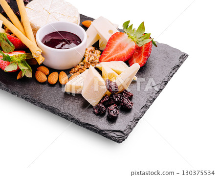 Delicious cheese platter with fruits and nuts arranged on a slate board Delicious cheese platter with fruits and nuts arranged on a slate board 130375534