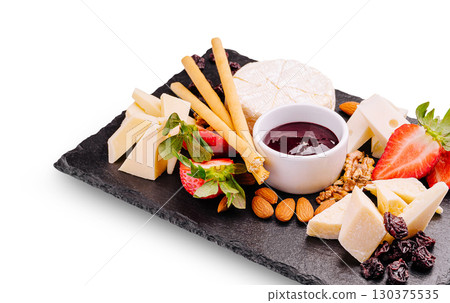 Cheese and fruit platter with jam served on a slate board at a gathering Cheese and fruit platter with jam served on a slate board at a gathering 130375535
