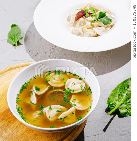 Delicious soup with dumplings served with fresh herbs in a bright setting Delicious soup with dumplings served with fresh herbs in a bright setting 130375549
