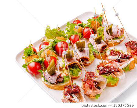 Delicious assortment of gourmet appetizers on a white platter Delicious assortment of gourmet appetizers on a white platter 130375589