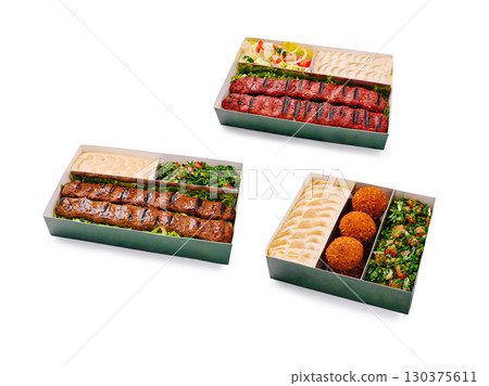 Delicious grilled kebabs and side dishes arranged in takeout boxes 130375611