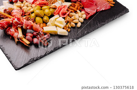 Assorted charcuterie and cheese platter on a slate board with nuts and olives 130375618