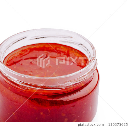 Spicy red sauce in a glass jar ready for culinary use 130375625