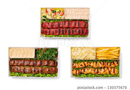 Delicious assortment of grilled meats and sides served in takeout containers Delicious assortment of grilled meats and sides served in takeout containers 130375678