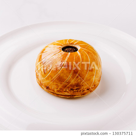Delicious pastry with a glossy finish garnished on a white plate Delicious pastry with a glossy finish garnished on a white plate 130375711