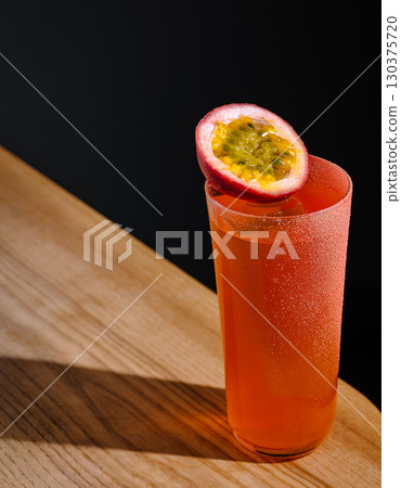Refreshing cocktail with passion fruit served in a tall glass at a bar Refreshing cocktail with passion fruit served in a tall glass at a bar 130375720