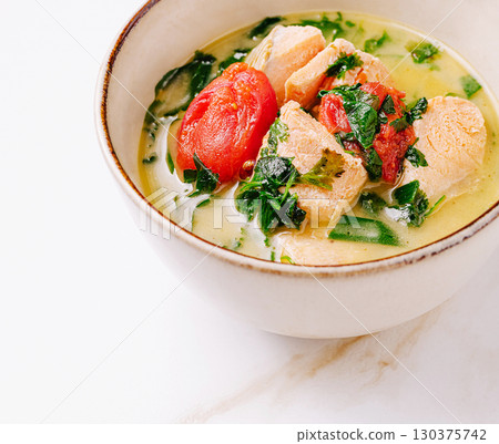 Creamy seafood soup with tomatoes and fresh herbs in a bowl Creamy seafood soup with tomatoes and fresh herbs in a bowl 130375742