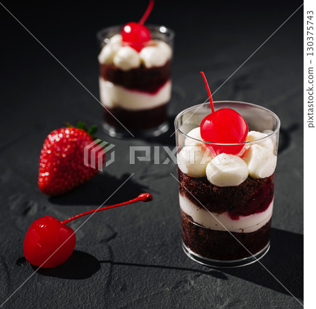 Delicious chocolate dessert cups with cherries and strawberries in focus Delicious chocolate dessert cups with cherries and strawberries in focus 130375743
