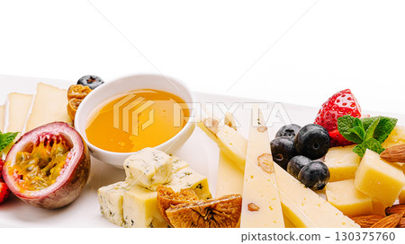 Delicious cheese and fruit platter with honey and nuts at a gathering 130375760