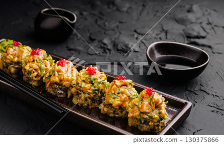 Sushi rolls with spicy mayo and roe served at a restaurant Sushi rolls with spicy mayo and roe served at a restaurant 130375866
