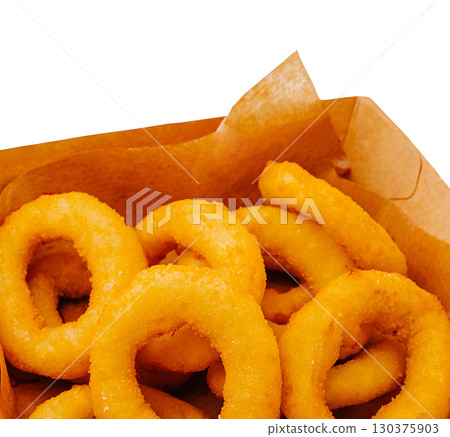 Crispy golden onion rings served in a paper basket at a casual eatery 130375903