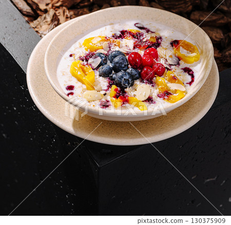Colorful bowl of yogurt topped with fresh fruit on a sunny day Colorful bowl of yogurt topped with fresh fruit on a sunny day 130375909