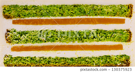 Layers of vibrant green and orange dessert displayed on a plate Layers of vibrant green and orange dessert displayed on a plate 130375923