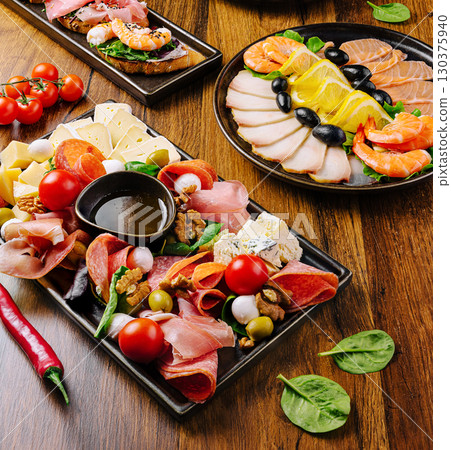 Delicious charcuterie platter featuring various cheeses and meats 130375940