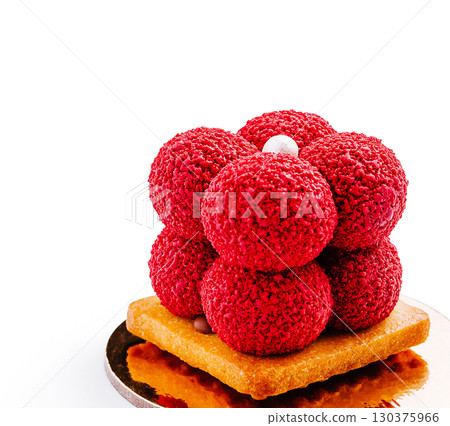 Delicious dessert with vibrant red spheres on a golden base at a bakery Delicious dessert with vibrant red spheres on a golden base at a bakery 130375966