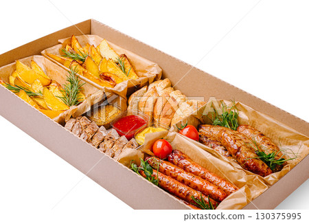 Delicious mixed platter featuring meats, potatoes, and bread for sharing 130375995