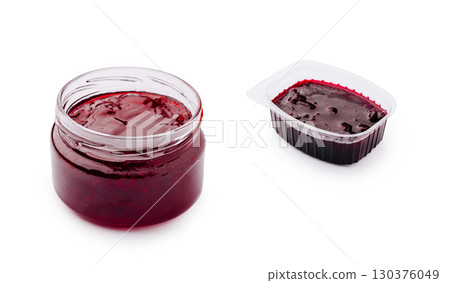 Glass jar and plastic container filled with red barbecue sauce or fruit jam, isolated on white background 130376049
