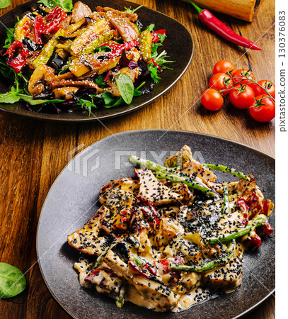 Delicious gourmet dishes featuring grilled chicken and vibrant vegetables 130376083