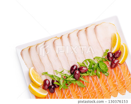 Freshly sliced seafood platter featuring salmon, white fish, and garnishes Freshly sliced seafood platter featuring salmon, white fish, and garnishes 130376153