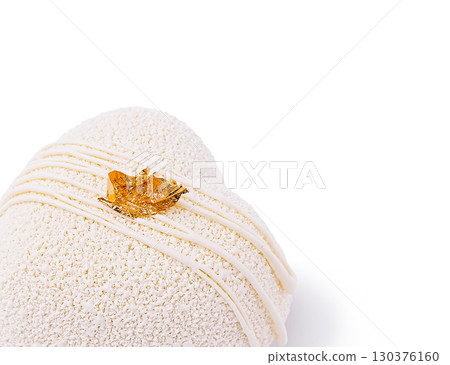 Intricate dessert with gold leaf detail showcased on white background 130376160
