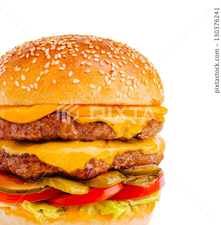 Juicy cheeseburger with layers of beef, cheese, and fresh toppings Juicy cheeseburger with layers of beef, cheese, and fresh toppings 130376241