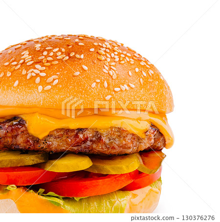 Juicy burger with cheese, lettuce, and pickles on a sesame seed bun 130376276