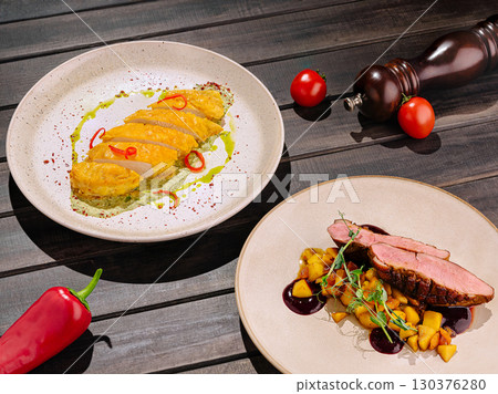 Gourmet duck dish with flavorful accompaniments at a fine dining restaurant 130376280