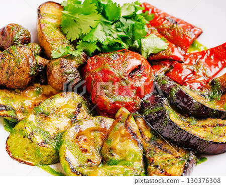 Grilled vegetables garnished with cilantro served on a white plate 130376308