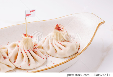 Delicious dumplings served on a beautiful plate at a gourmet restaurant Delicious dumplings served on a beautiful plate at a gourmet restaurant 130376317