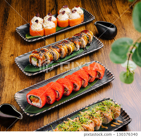 Delicious sushi assortment served on elegant black plates at a sushi restaurant 130376340