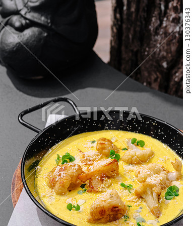 Delicious seafood dish served in a skillet at a cozy outdoor restaurant 130376343