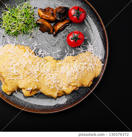 Pasta with mushrooms and cherry tomatoes on a dark background 130376372